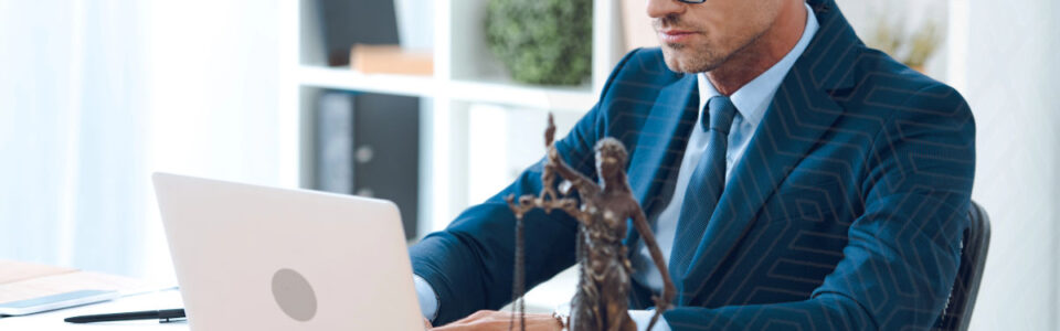 man with glasses sits at desk and uses CLM software for municipalities on computer