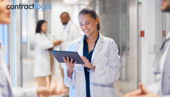 healthcare professionals speak while a woman in a lab coat uses contract management software for healthcare on a tablet