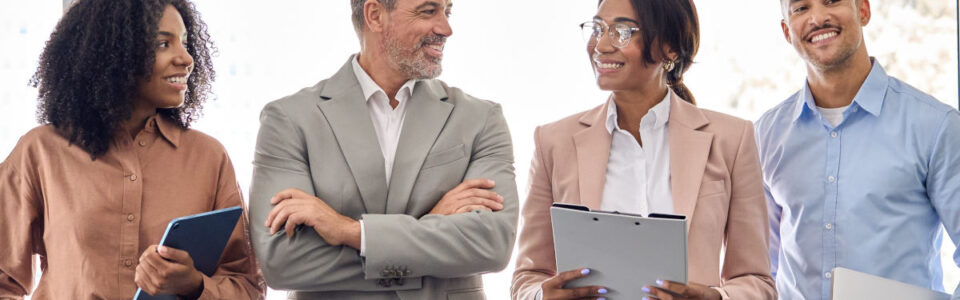 Four diverse contract managers discussing contract lifecycle management in a modern office.