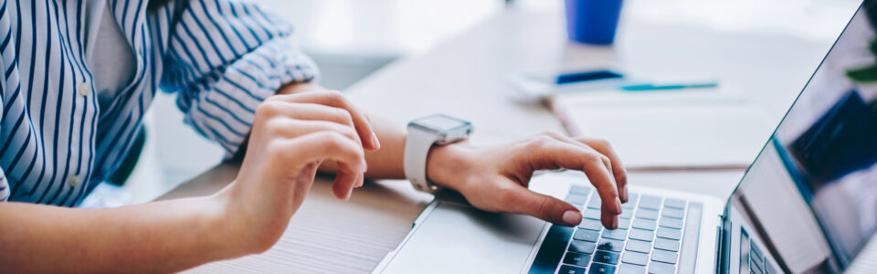 cropped image of female hands using the computer to access an automated contract management system