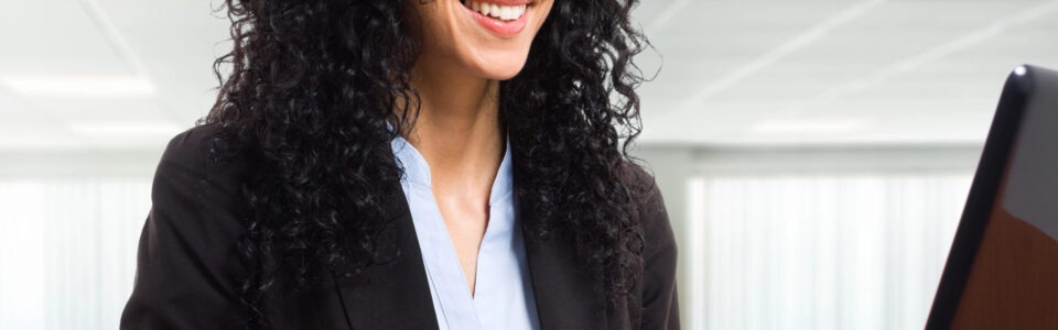 woman using contract negotiation software on laptop computer in office