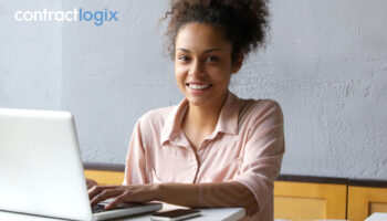 smiling woman uses laptop computer after learning what is contract lifecycle management software