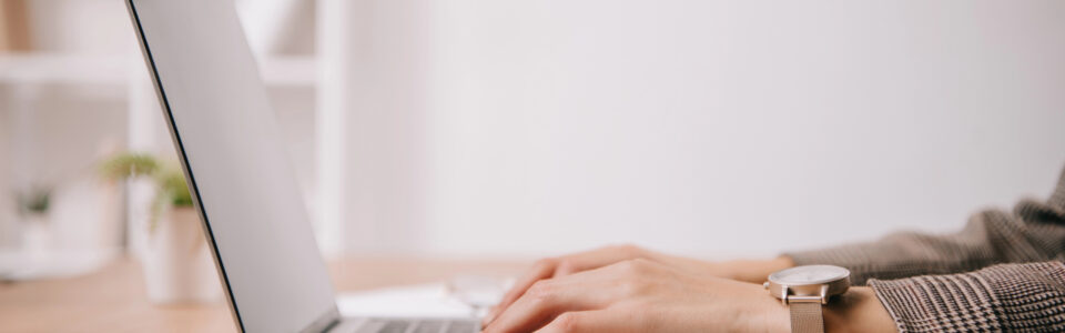 cropped view of businesswoman working and sitting at desk while using contract repository software