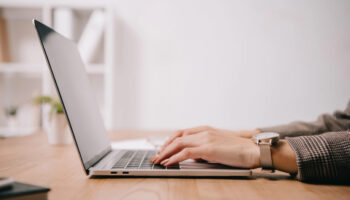 cropped view of businesswoman working and sitting at desk while using contract repository software