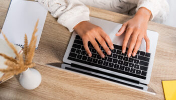 view of businesswoman typing on laptop at home to learn what is CLM software