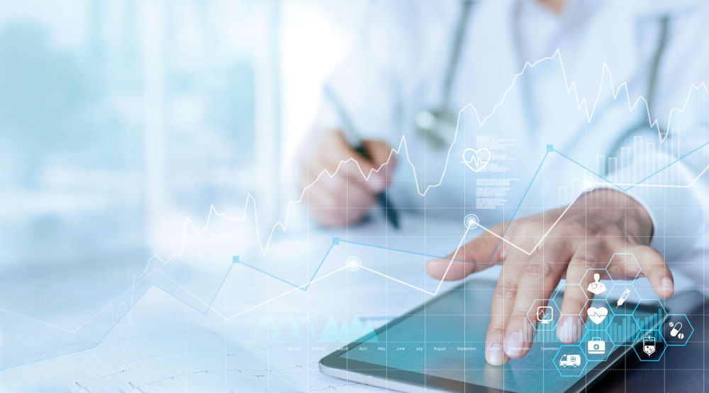 Healthcare professional using a digital tablet to use hospital contract management software to gain business insights